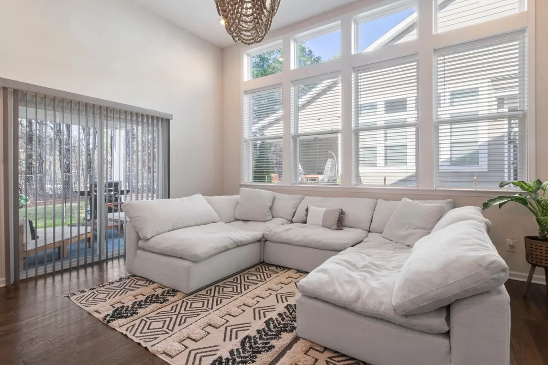 Bright, airy living room with a cream sectional sofa below tall windows